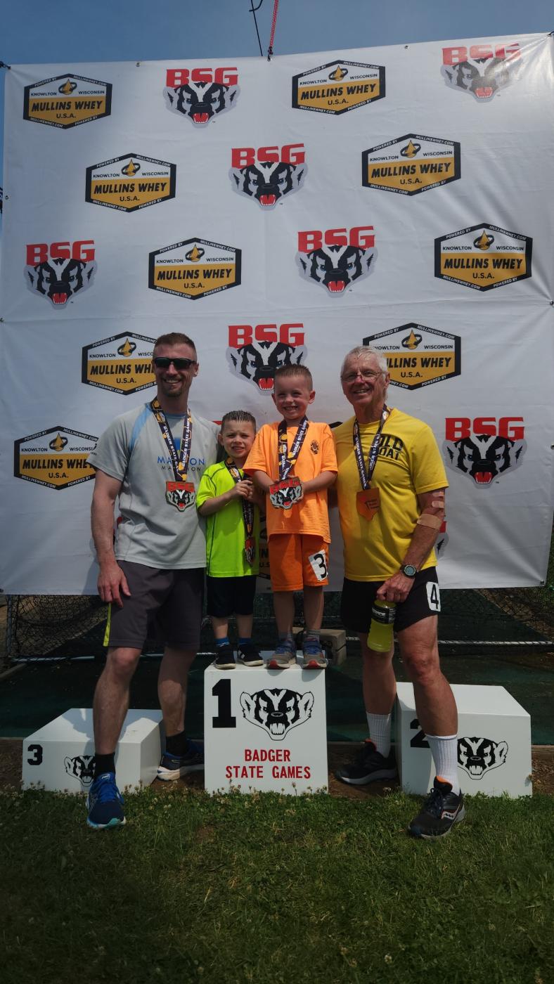 Eugene with his dad and two sons after running a multi-generational relay at the Wisconsin Badger State Games Track & Field Competition in 2023, and have&nbsp;repeated this tradition annually.